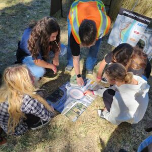 Students work with a local engineer to learn how to properly navigate a traffic roundabout as they learn about the pending construction of a parkway in the Horan Natural Area.