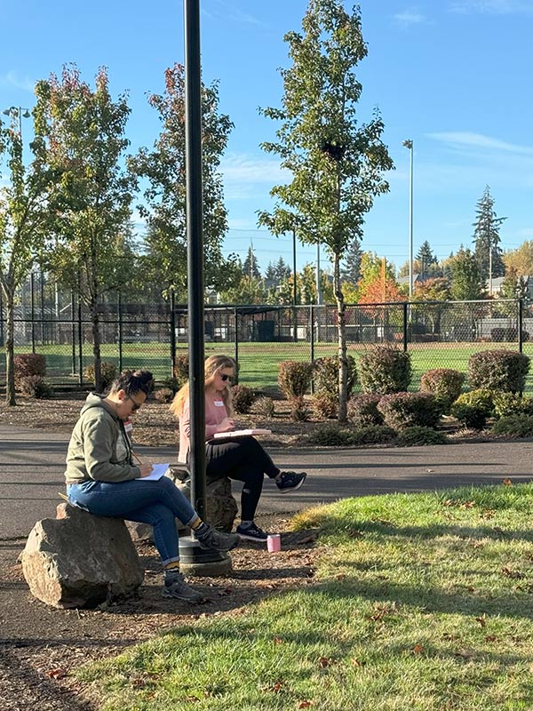 Teachers activate their senses to make observations during a sit spot activity